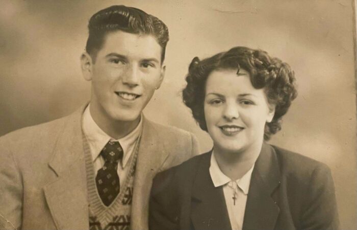 Candid old photo of a smiling couple, a man and a woman, from generations ago, showcasing what the world looked like back then.