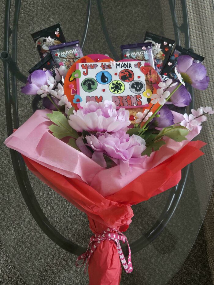 Valentine’s Day gifts bouquet with pink flowers, Magic cards, and a funny handmade card showing true love and laughter.