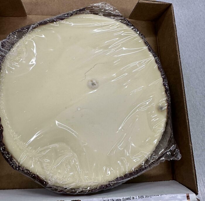Partially eaten cheesecake left in box with plastic wrap, illustrating people who are selfish and stupid to work with others.