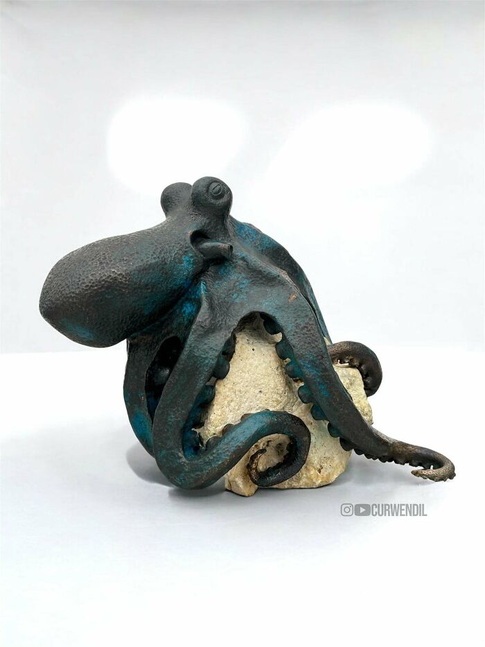 Metal octopus sculpture wrapped around a stone rock showcasing a creative DIY win project with artistic details.