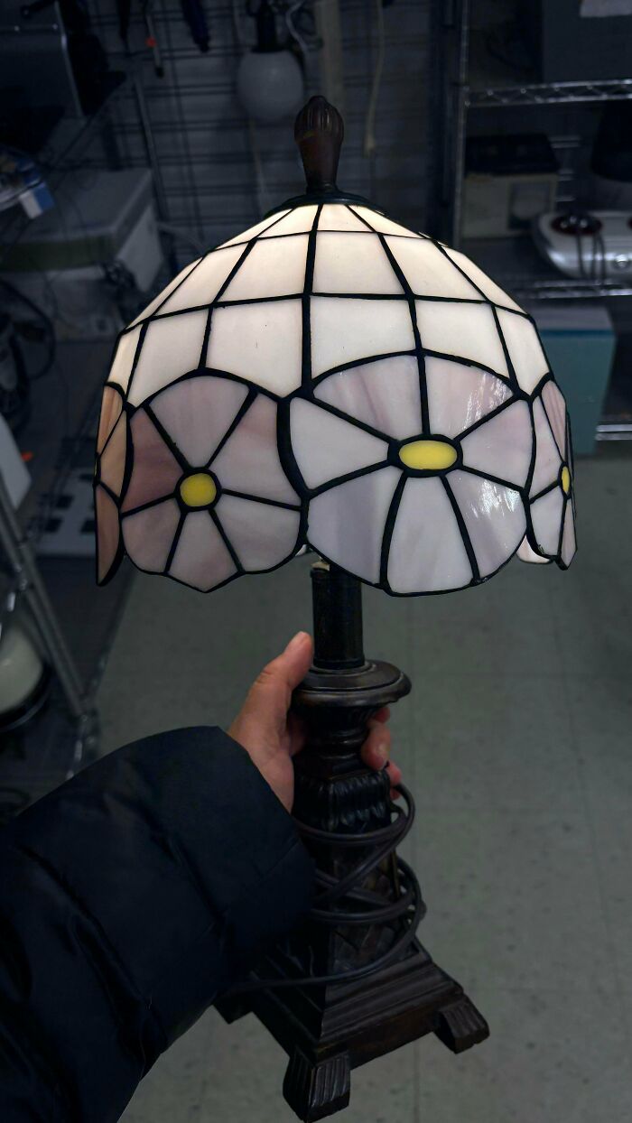 Hand holding a vintage stained glass lamp found at a thrift store, a true jackpot.
