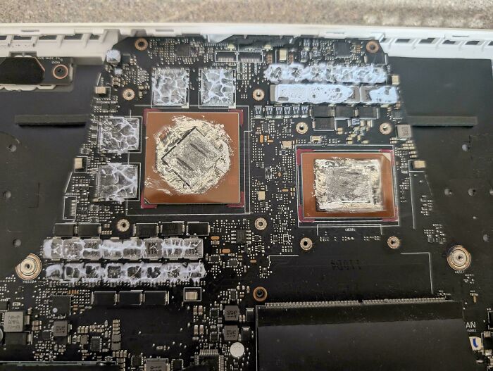 Close-up of a computer motherboard showing damaged processors with thermal paste residue, illustrating tech support challenges.