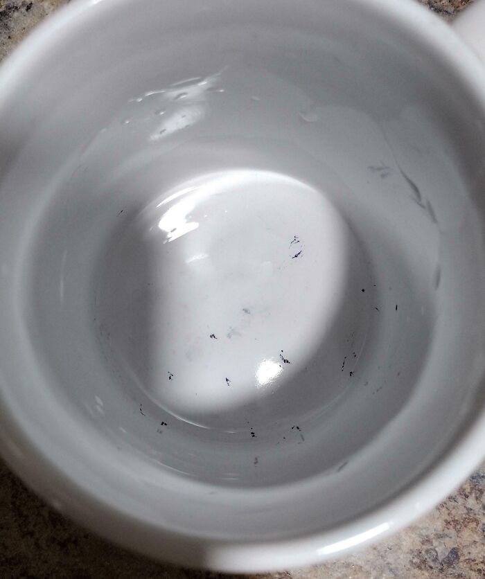 Close-up of a dirty white cup with black debris inside, illustrating selfish and careless behavior in everyday use.