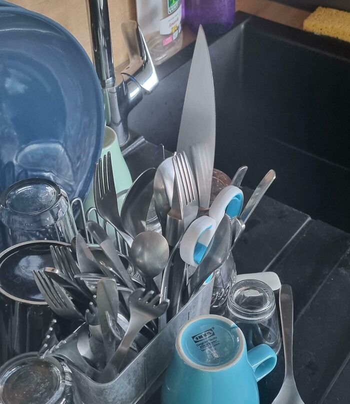 Kitchen sink cluttered with unwashed utensils and dishes, showing selfish and stupid behavior refusing to work with others.