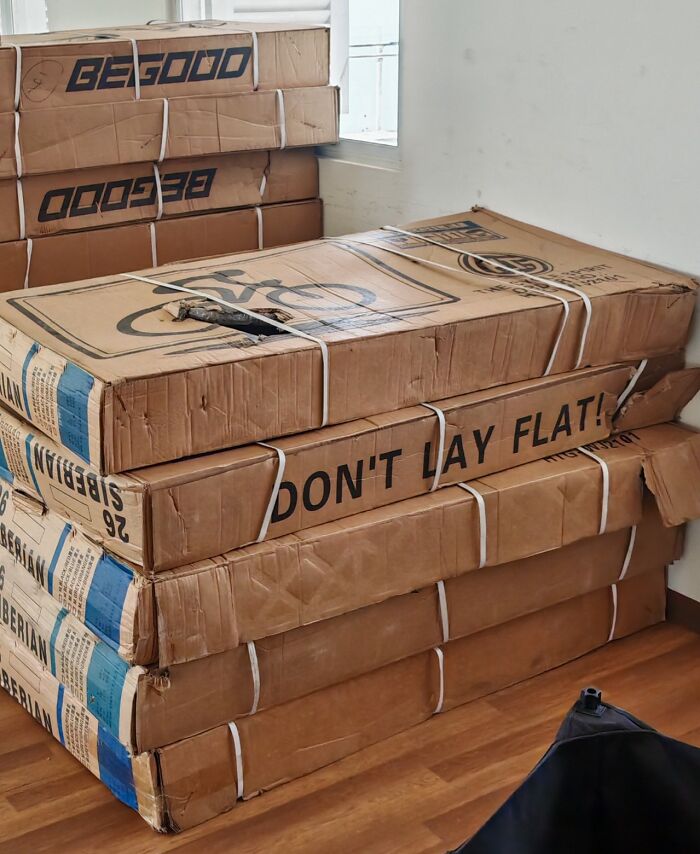 Stack of damaged cardboard boxes with fragile items inside showing selfish and stupid packing behavior.