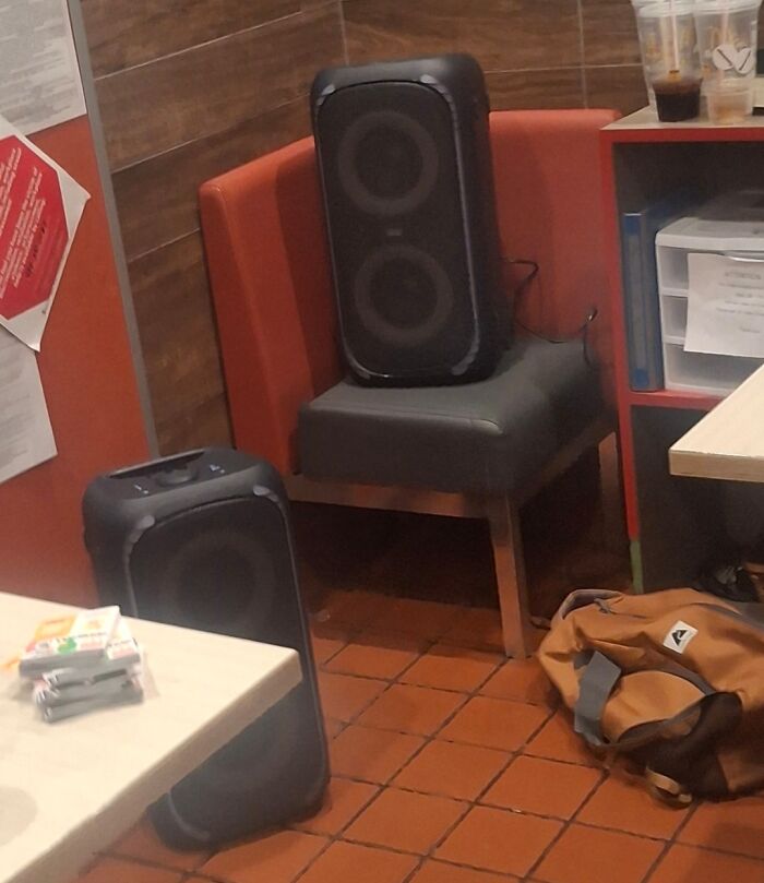 Two large speakers placed awkwardly in a small corner, illustrating selfish and stupid behavior in shared spaces.