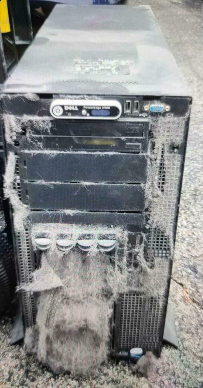 Dust-covered Dell PowerEdge server tower showing heavy neglect, illustrating tech support worker challenges and frustrations.