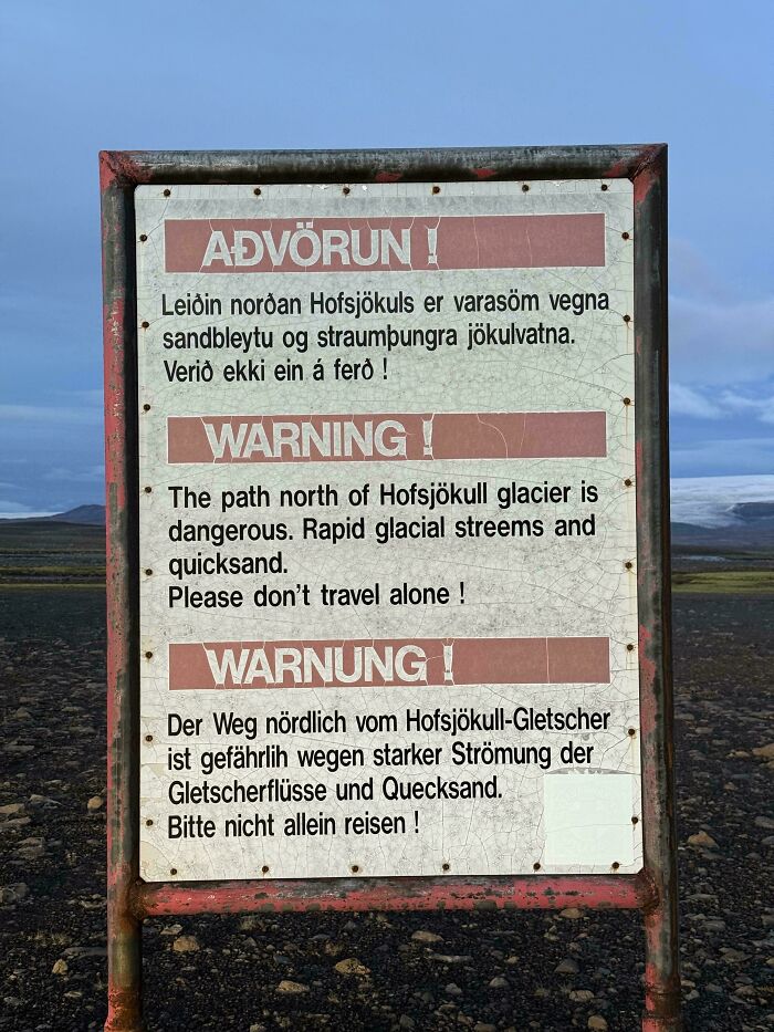 Warning sign near Hofsjökull glacier cautioning about dangerous rapid glacial streams and quicksand, a scary sign in the wild.