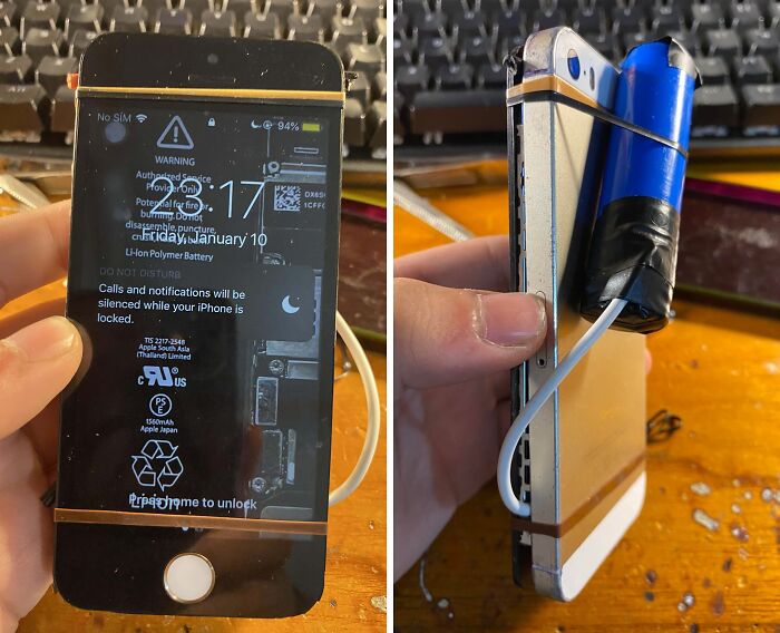 Old iPhone held with homemade battery pack taped to the back, illustrating tech support worker DIY repairs.