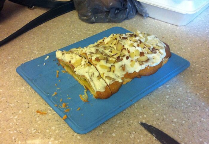 Partially sliced almond cake on a blue cutting board, illustrating boomers trying technology and kitchen tools fails.
