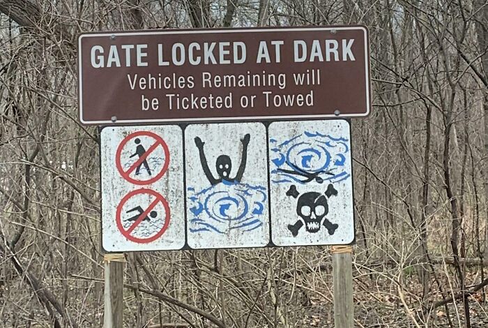 Warning sign showing gate locked at dark with symbols of no walking, drowning hazard, and skull, related to hitchhikers escaping inmates.