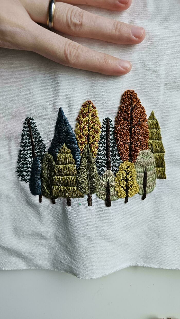 Detailed embroidery creation of a forest of trees on white fabric, inspiring new hobby.