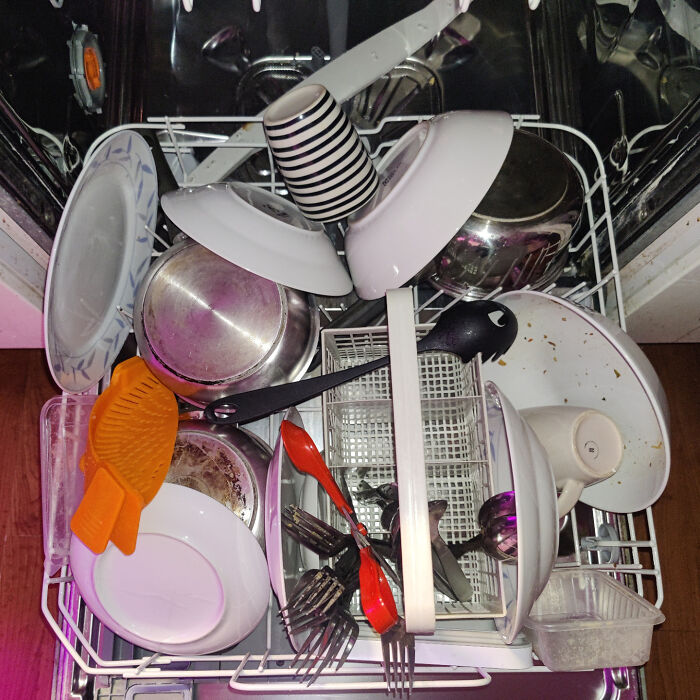 Dishwasher loaded with dirty dishes and utensils, showcasing a partner’s most frustrating habits in messy kitchen cleanup.