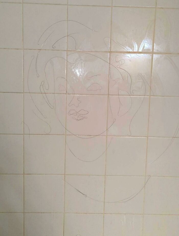Frustrating habit of shaving hair into a face outline on bathroom tiles shown in photo.