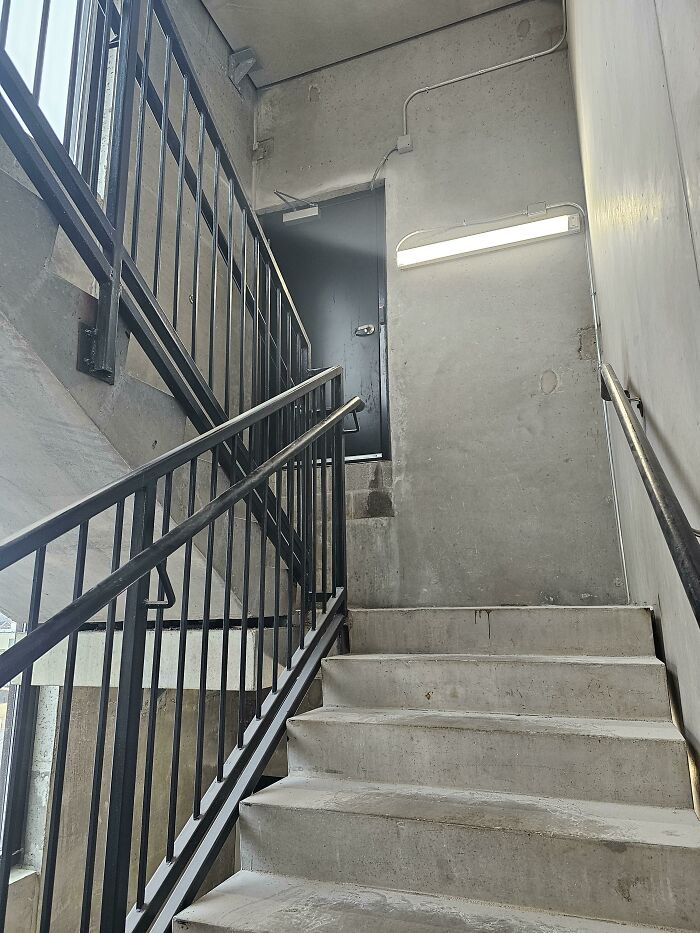 Concrete staircase with a door at the top leading to a solid wall, an example of architects failing and doors that lead nowhere.