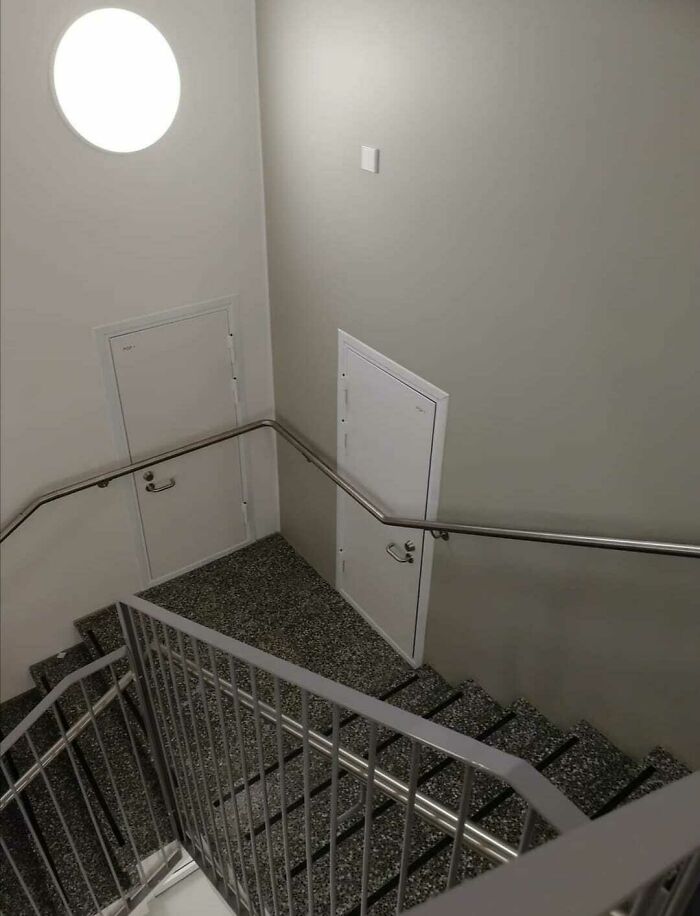 Two doors in a stairwell lead nowhere, showcasing a clear architectural fail in door placement and design.