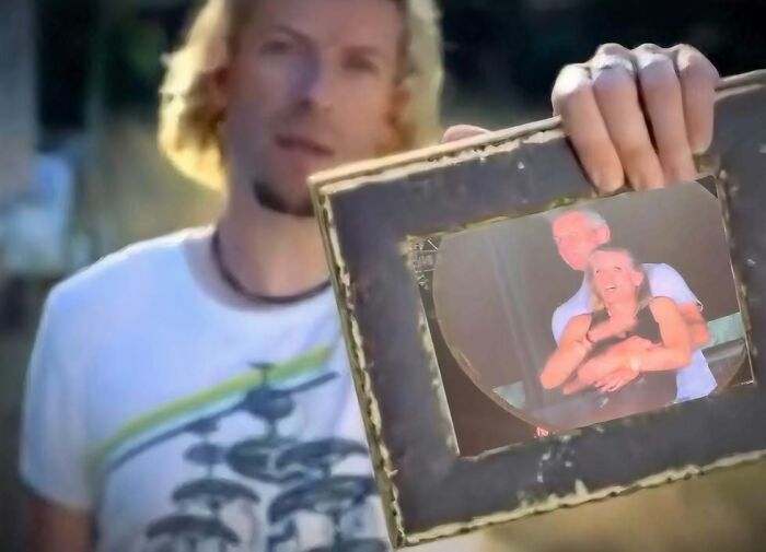 Man with blond hair holding a framed photo of a couple, a relatable image from hilarious memes that don’t explain themselves.