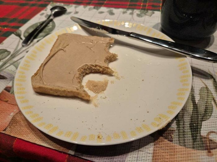 Partially eaten peanut butter toast on a plate with a knife, illustrating a partner’s frustrating eating habit.