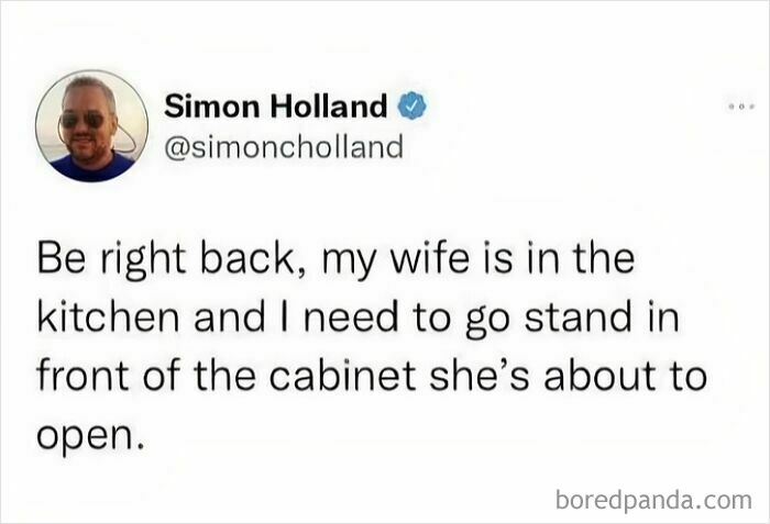 Tweet text about marriage humor where husband says he needs to stand in front of the kitchen cabinet wife is about to open.