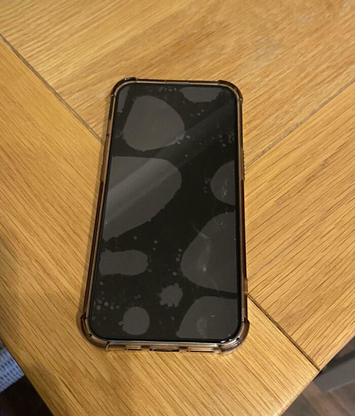 Smartphone screen with large smudge marks illustrating one partner’s most frustrating habits shared by 57 people.