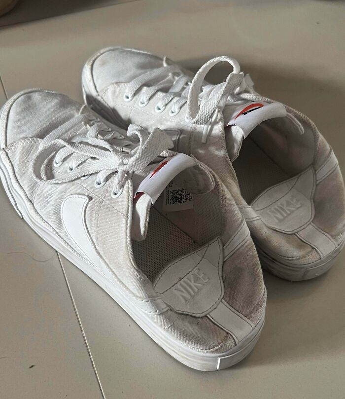 Worn-out white Nike sneakers showing a partner’s most ridiculously frustrating habit of shoe neglect.