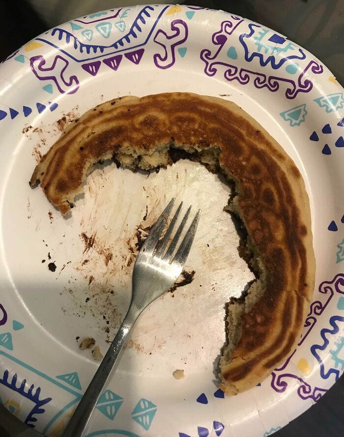 Partially eaten pancake with uneven bites on a paper plate, illustrating partners’ most frustrating habits.