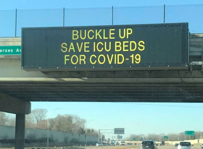 Highway sign reading buckle up to save ICU beds for COVID-19, one of the scariest signs ever spotted in the wild.