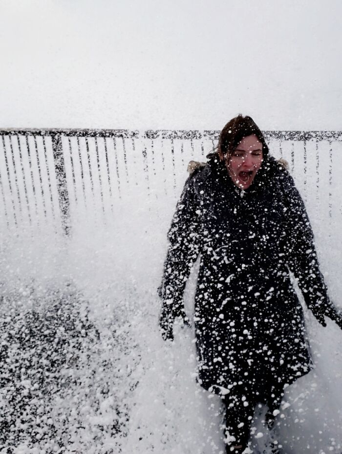 Person caught in an unexpected snow splash, creating a surprising and better photo moment than expected.