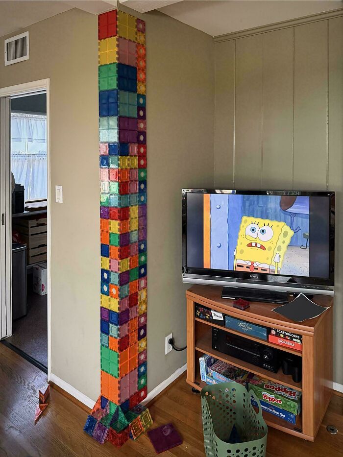 A funny photo showing what it means to be a great dad, with a tall tower of magnetic blocks next to a TV.