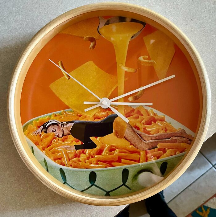 A quirky clock featuring a woman in a black dress lying in a bowl of macaroni and cheese, a jackpot find from a thrift store.