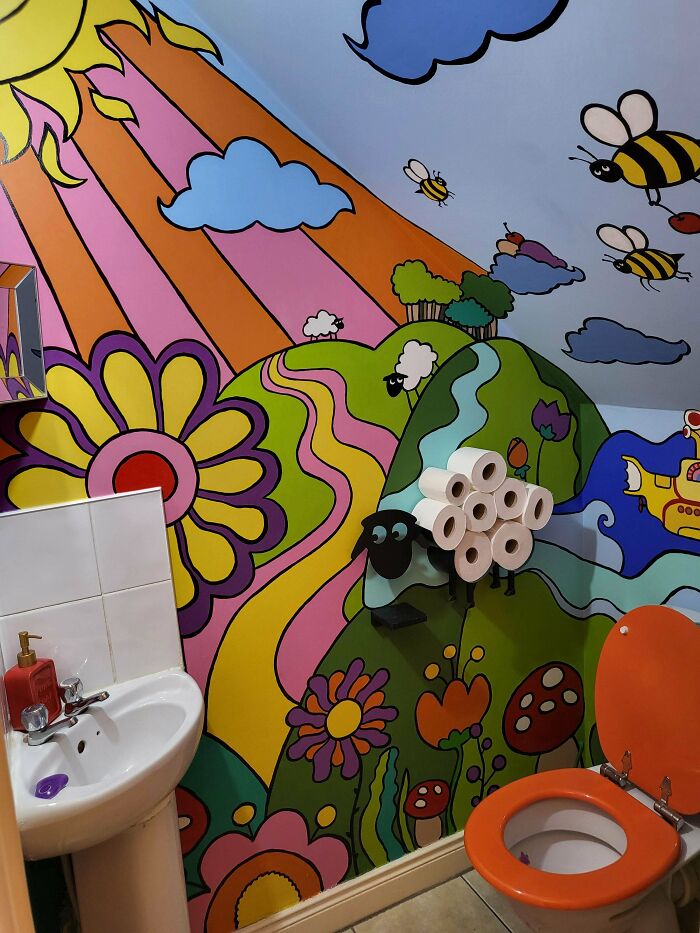 Colorful bathroom mural with bees, flowers, and hills embracing more is more home decor style