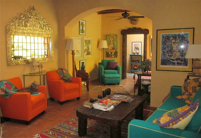 Colorful living room decked out with eclectic furniture and vibrant decor embracing more is more home design style.