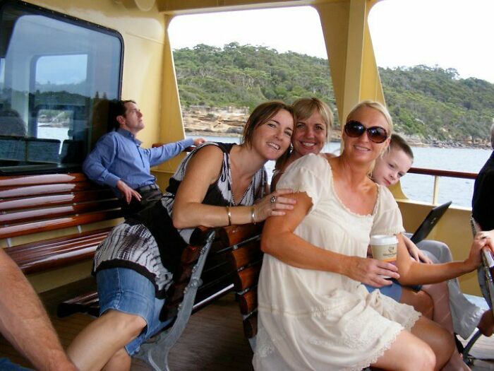 Group of people on a boat smiling and relaxing, capturing an unexpected better photo moment than they planned.