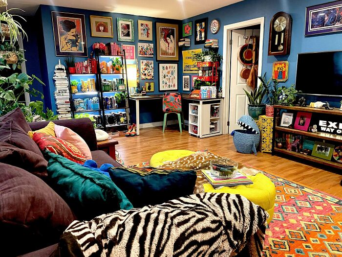 Colorful living room with eclectic decor, vibrant wall art, and layered textiles embracing more is more home design.