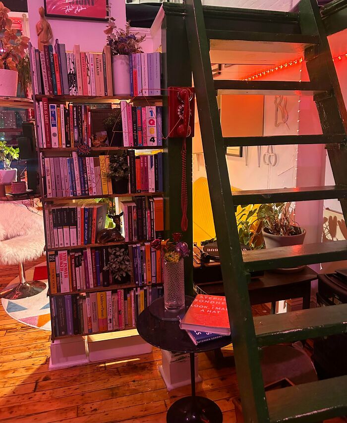 Cozy home packed with colorful books, plants, and eclectic decor embracing more is more interior design style.