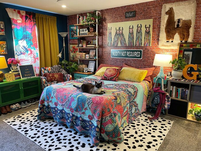 Eclectic bedroom embracing more is more style with colorful bedding, patterned rug, wall art, and abundant decor details.