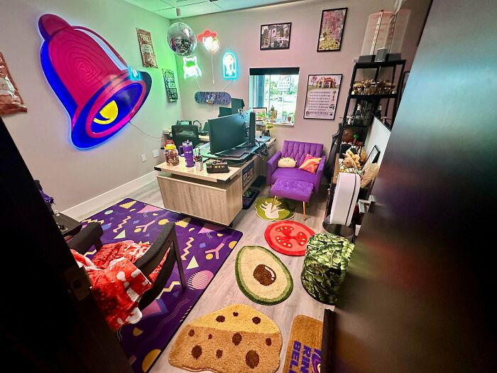 Vibrant home decorated with colorful rugs, neon Taco Bell sign, eclectic furniture, and playful wall art embracing more is more style.