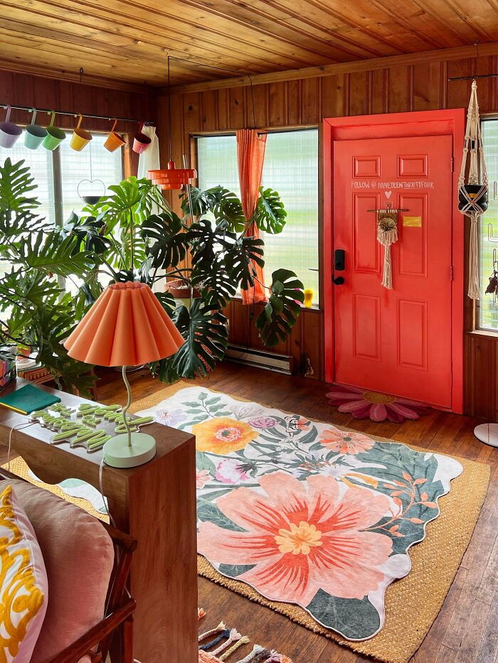 Colorful eclectic living room showcasing more is more home decor style with vibrant plants and bold patterns.