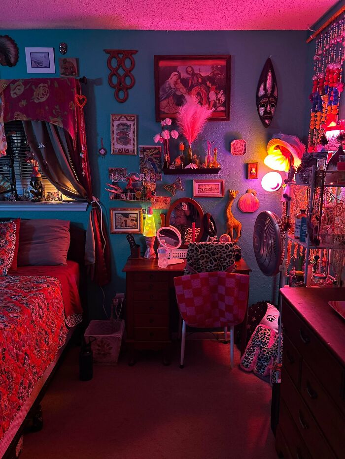 Eclectic home interior with colorful decor, filled shelves, patterned textiles, and vibrant lighting showcasing more is more style.