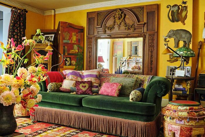 Eclectic living room with vibrant pillows, layered decor, and colorful accents showcasing a more is more home style.