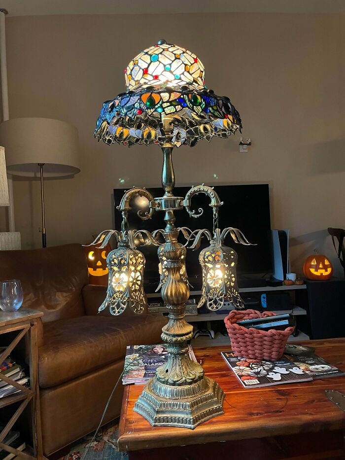 Ornate vintage lamp with stained glass shade in a cozy living room showcasing more is more home decor style.