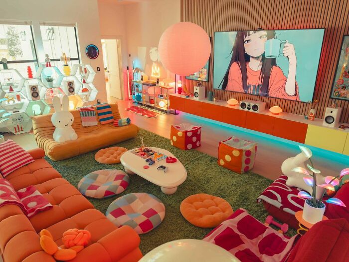 Colorful living room decked out with plush seating, playful decor, and vibrant lighting embracing more is more home style.