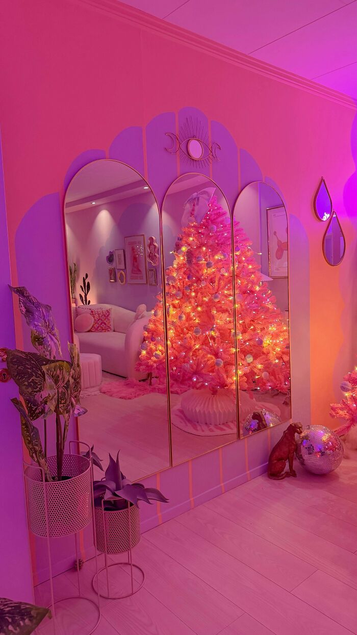 Vibrant home decorated with a glowing pink Christmas tree and eclectic decor embracing more is more home design.