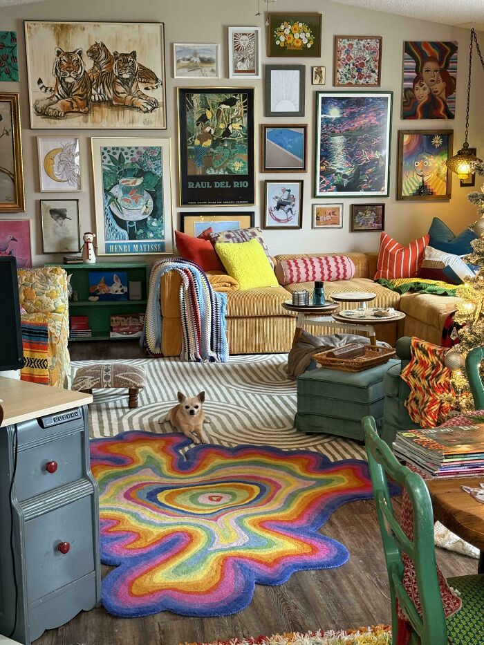 Colorful eclectic living room with layered art, vibrant pillows, and a bold rainbow rug embracing more is more home decor style.