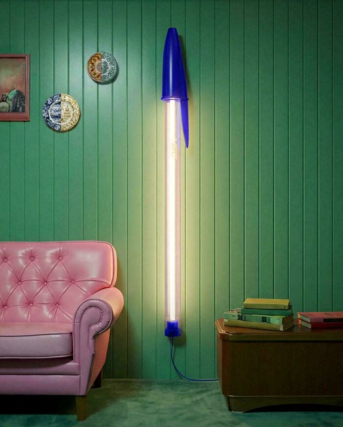 Oversized pen-shaped lamp lighting a vibrant retro living room embracing more is more home decor style.