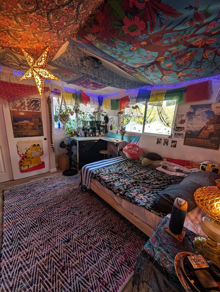 Colorful bohemian bedroom decorated with vibrant tapestries, plants, and eclectic furnishings embracing more is more home style.