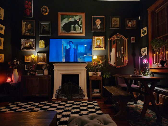 Cozy living room decked out with eclectic framed art, plants, and layered decor embracing the more is more home style.