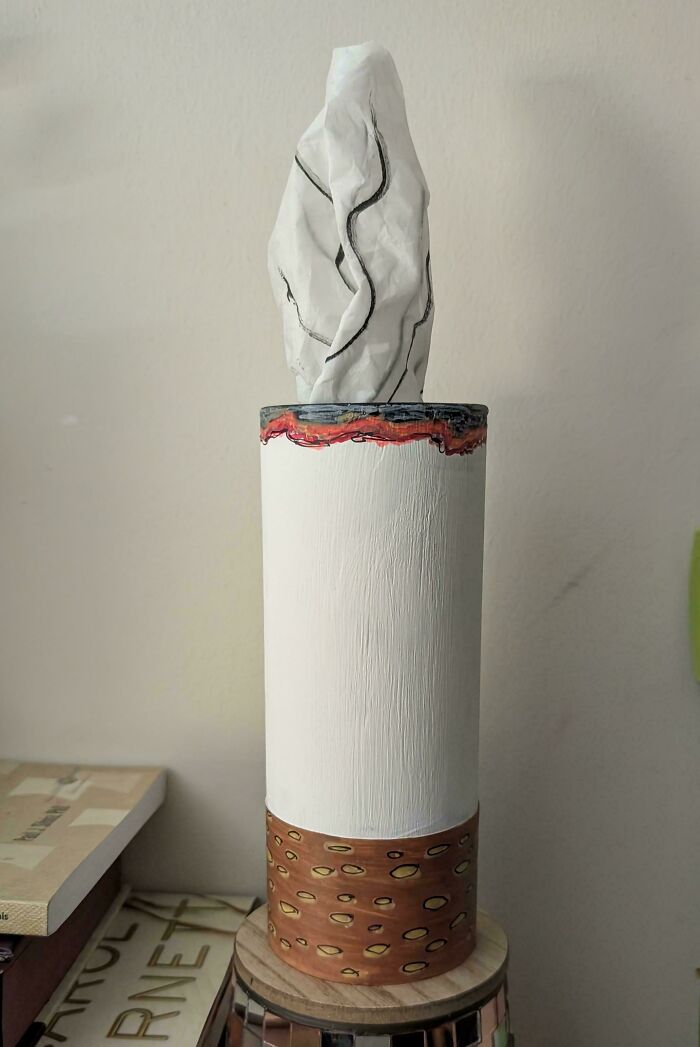 DIY project tissue holder made from painted materials with a crumpled paper resembling a tissue sticking out.
