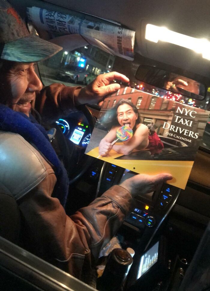 Taxi driver holding a humorous NYC taxi drivers calendar inside a car at night, capturing a funny photo moment.