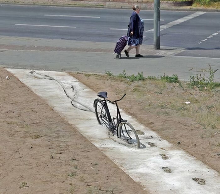 Bike seemingly stuck in a painted riverbed on the ground, creating a funny photo that says it all instantly.